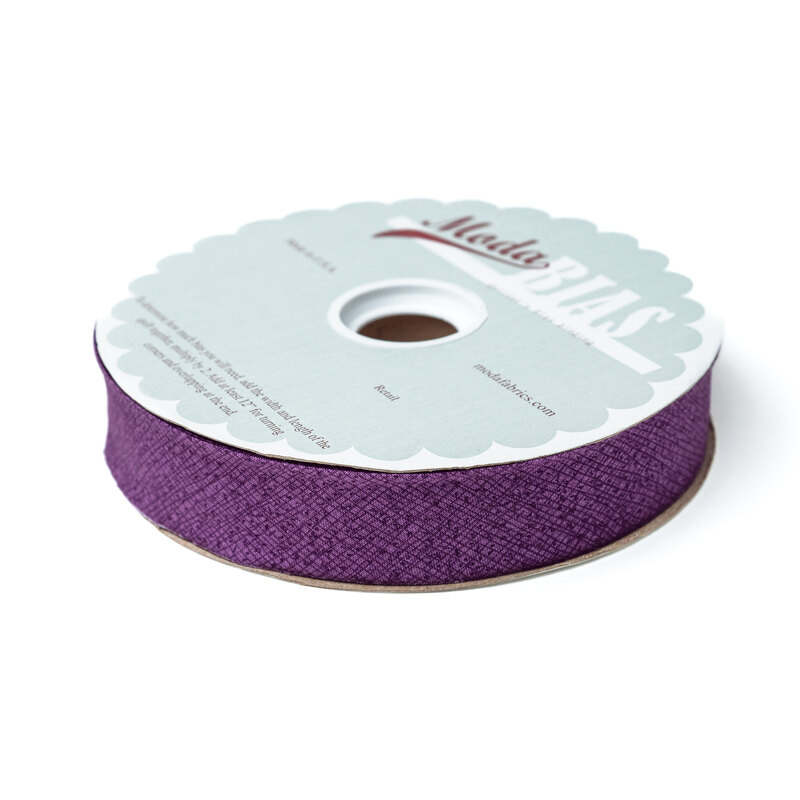 Spool of purple bias tape isolated on a white background