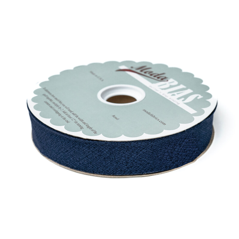 Spool of dark blue bias tape isolated on a white background