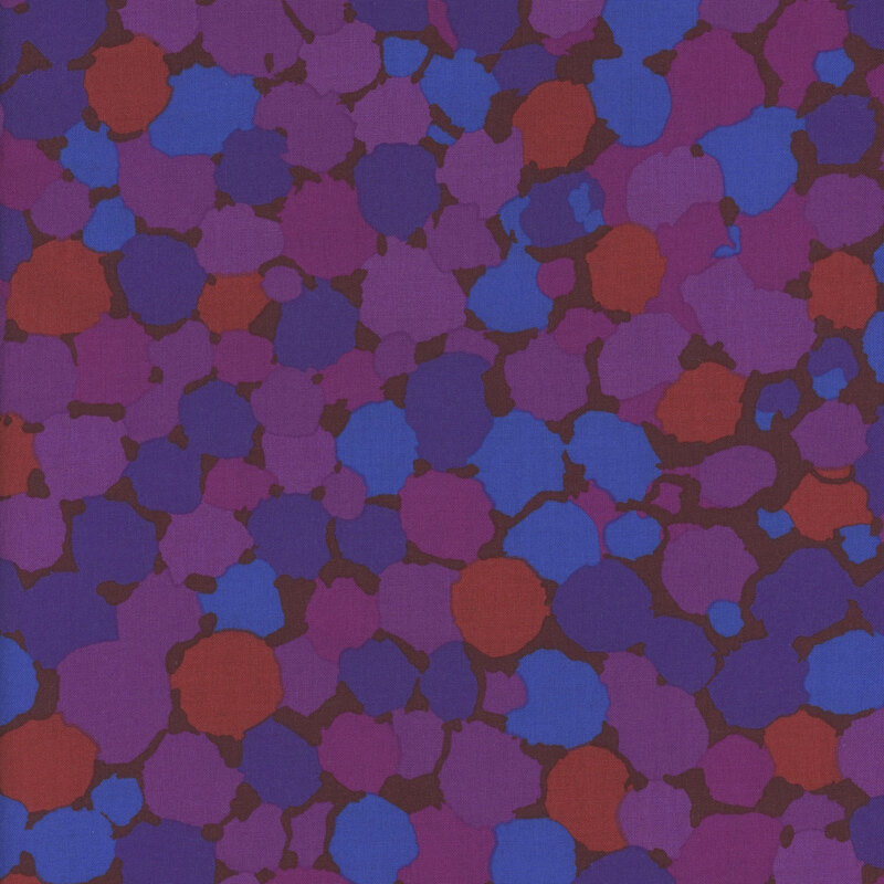 Abstract pattern of overlapping circles in shades of purple, blue, and red on a dark background.