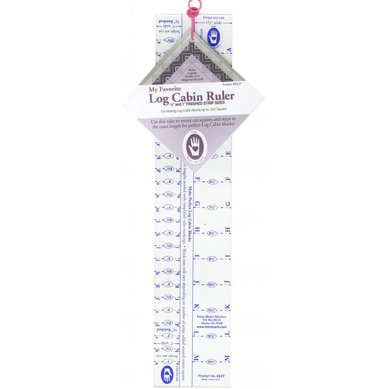 A log cabin ruler with measurements, helpful for quilting and crafting, hangs from a pink loop.