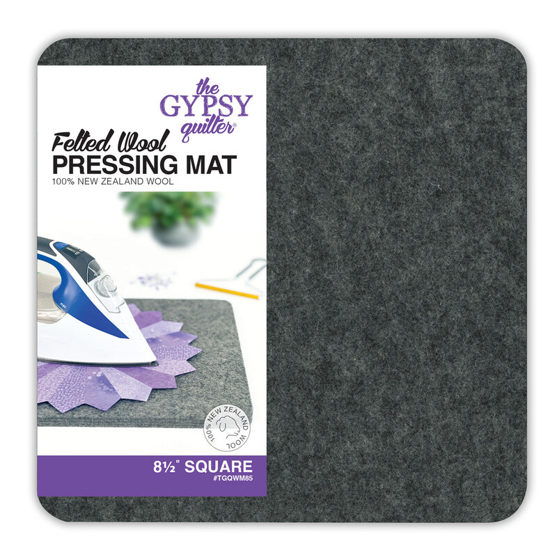 A square wool pressing mat with packaging, featuring an iron and colorful fabric squares.