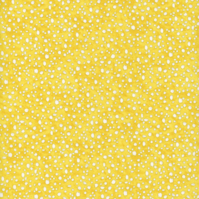 fabric pattern of white dots scattered all over a yellow marbled background