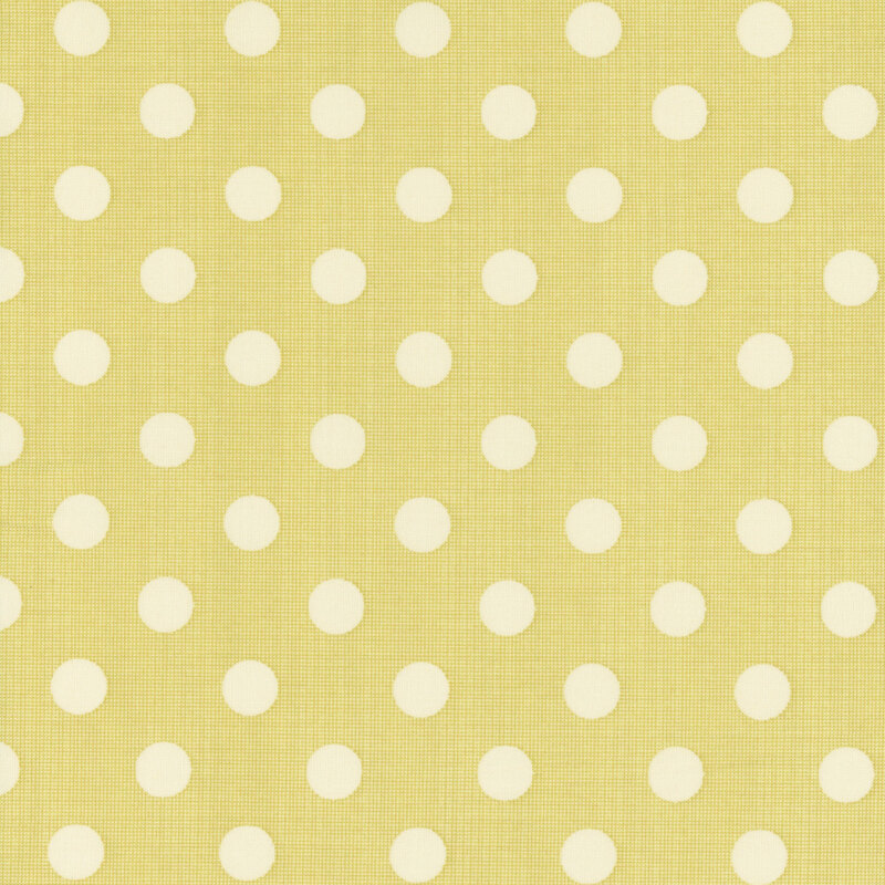 A mustard yellow fabric featuring evenly spaced cream polka dots.
