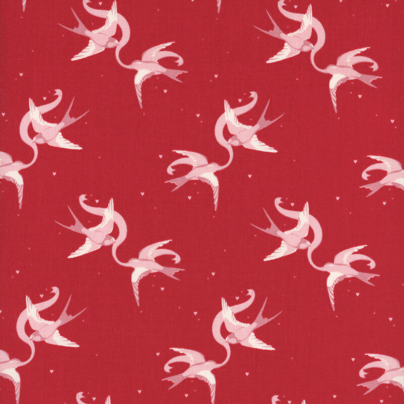 Red fabric with rotating couples of swallows holding a ribbon between them.