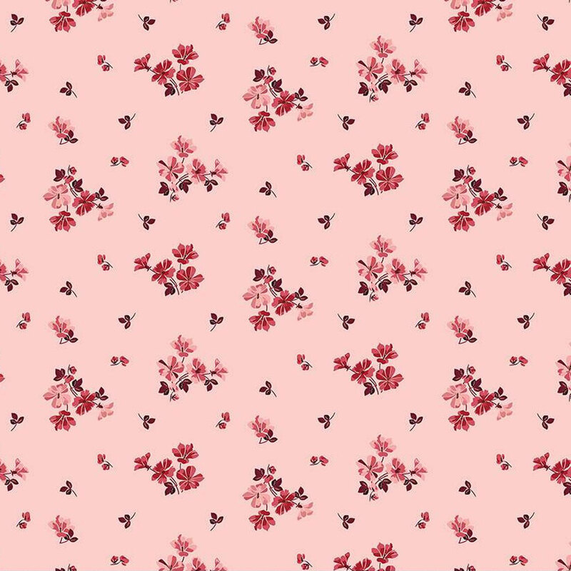 A pink fabric pattern featuring small clusters of red and dark flowers with accompanying leaves.