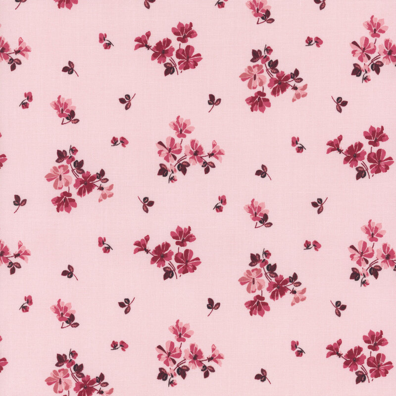 A pink fabric pattern featuring small clusters of red and dark flowers with accompanying leaves.