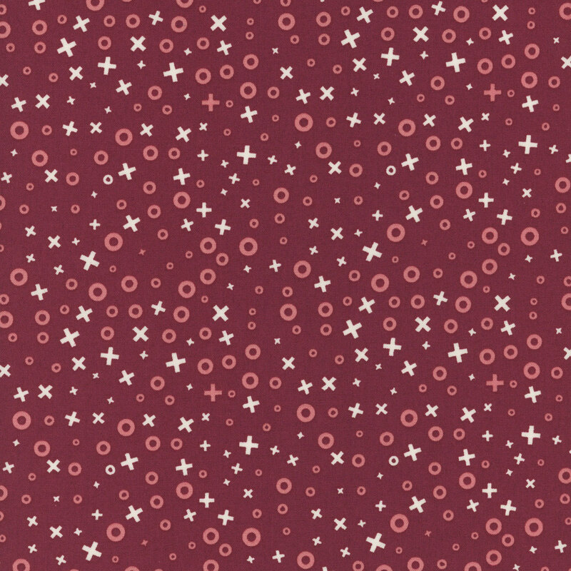 Red fabric pattern with various sizes of circles and crosses in pastel colors.