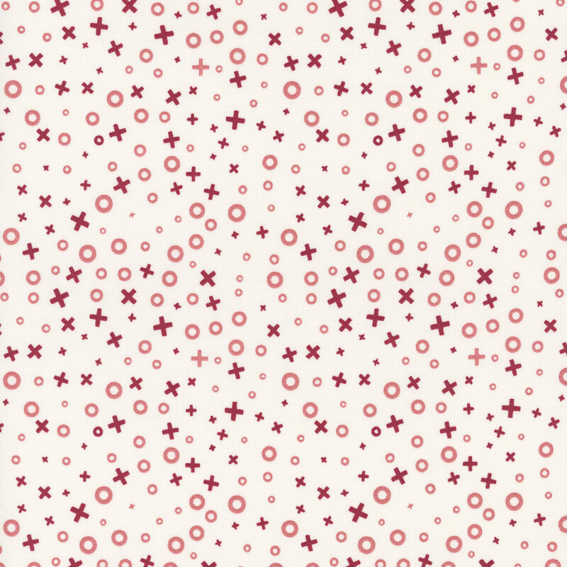 Repeating pattern of red circles and crosses on a light cream fabric.