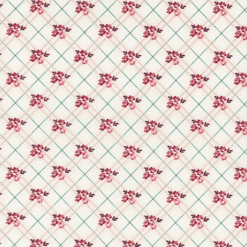 A repeating floral pattern with pink flowers on a white fabric, outlined by green diamonds.