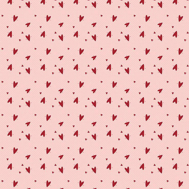 A light pink fabric with a scattered pattern of small red hearts.