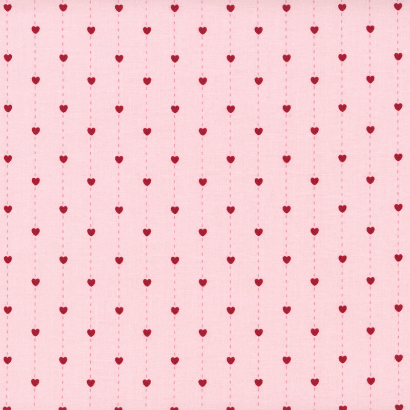fabric pattern of hearts over a pink background