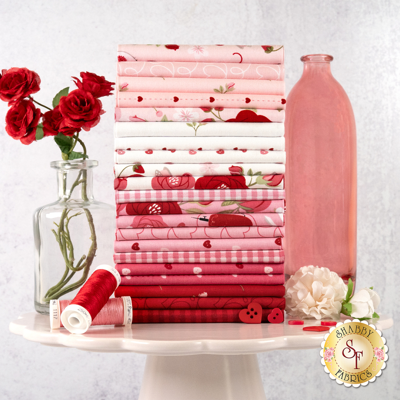 A stack of fabric with a jars and flowers and thread and buttons.