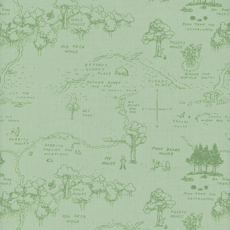 A green fabric featuring a hand-drawn map of 100 acre woods with trees, paths, and labeled locations.
