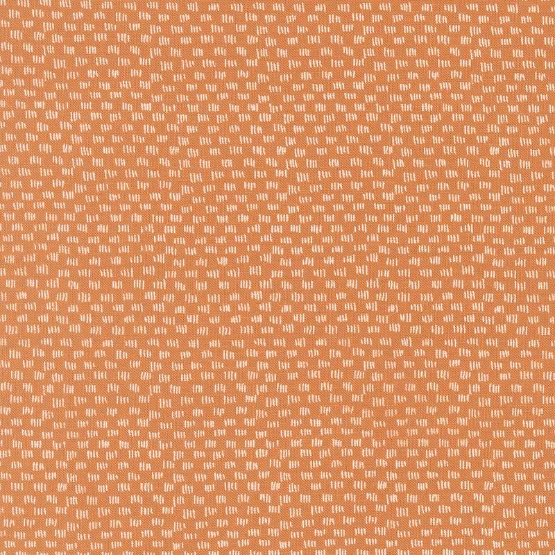 Orange fabric featuring a repeating pattern of small white shapes.