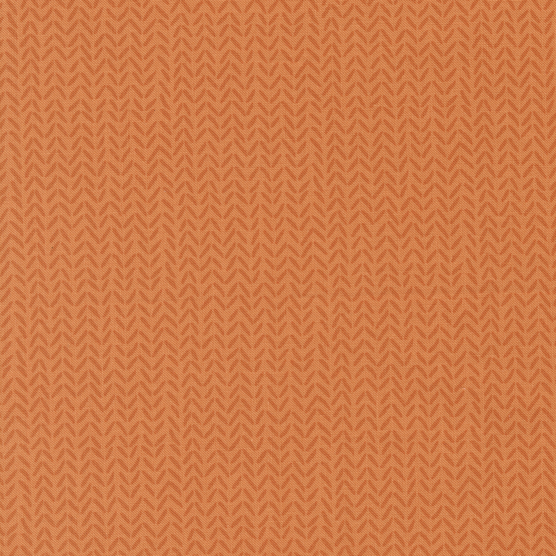 Tonal orange fabric with a subtle repeating herringbone pattern