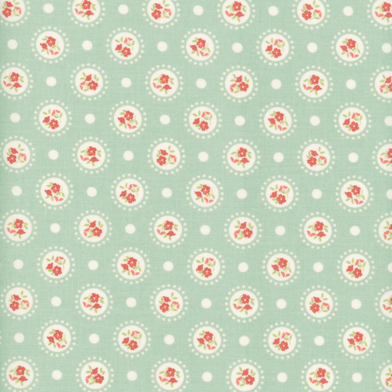 Dark aqua fabric with medallions of red flowers on a polka dotted background.