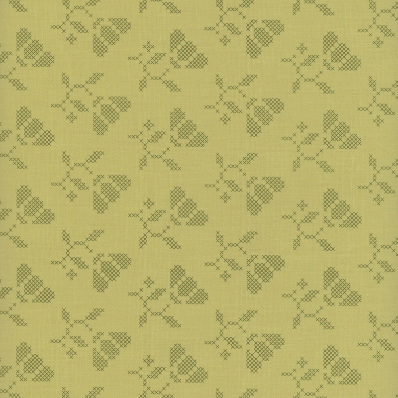 Tonal green fabric with cross-stitched flowers.