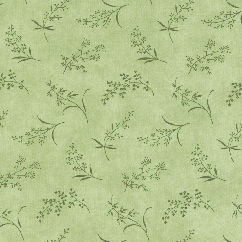 Fabric pattern of ditsy leaves and flowers on a green background.