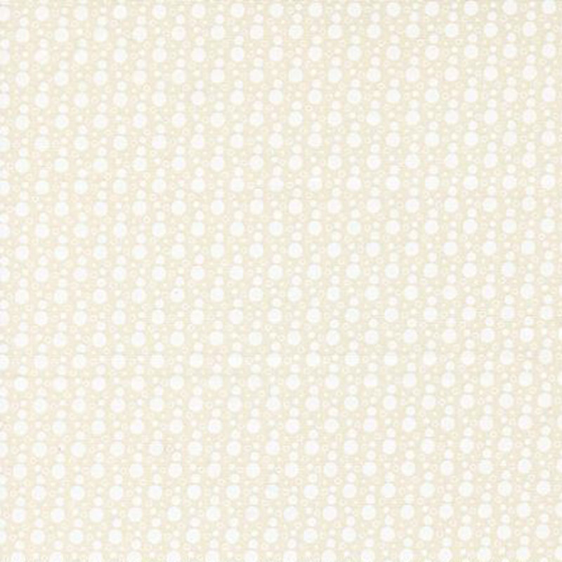 fabric pattern of whtie dots all over a cream background