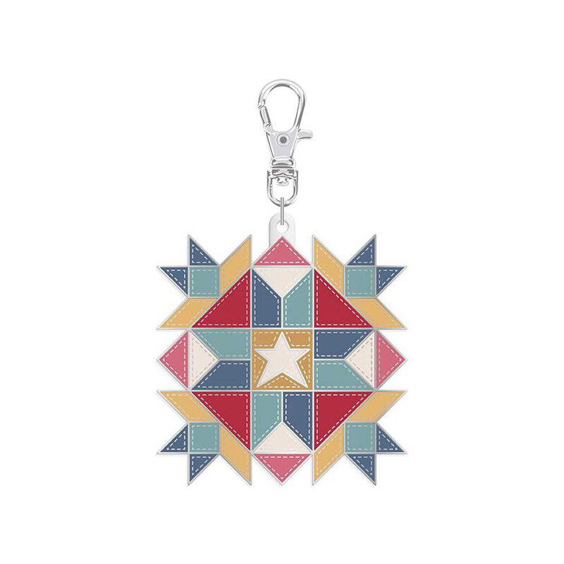 Enamel pin with a metal clip featuring the design of a quilting star block, isolated on a white background.