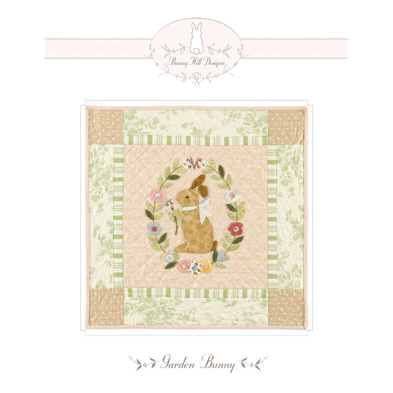 A quilt design featuring a brown bunny in a floral wreath, surrounded by green and beige patterns.