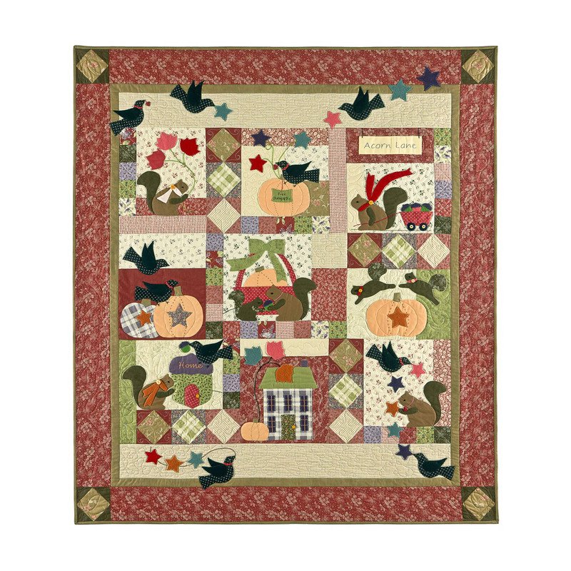 Colorful quilt featuring squirrels, pumpkins, and birds in a patchwork design with autumn themes.