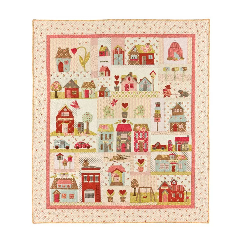 A quilt featuring colorful patchwork designs of various houses, hearts, and trees on a light background.