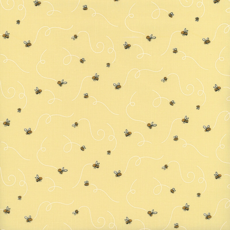 Pastel yellow fabric with buzzing bees leaving swirling air trails behind them.