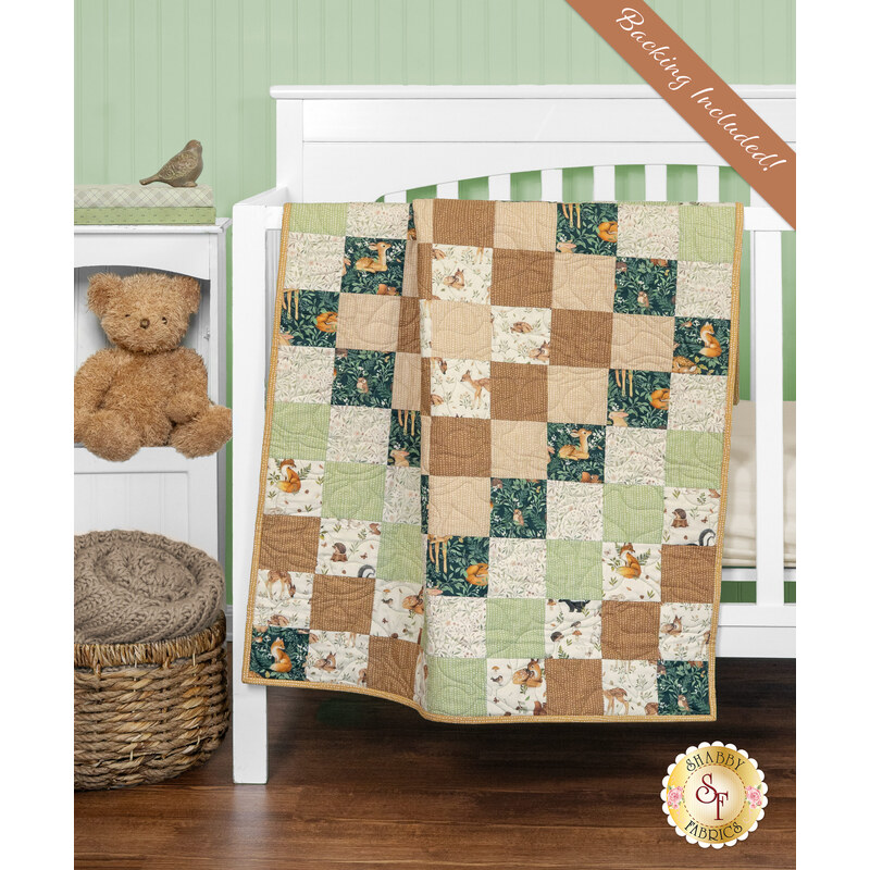 A patchwork quilt draped over a crib, featuring earthy tones and whimsical animal patterns next to coordinating decor. 