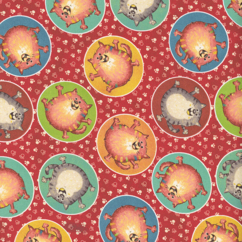 Red fabric with ditsy cartoon cats in circular frames on a pawprint background.