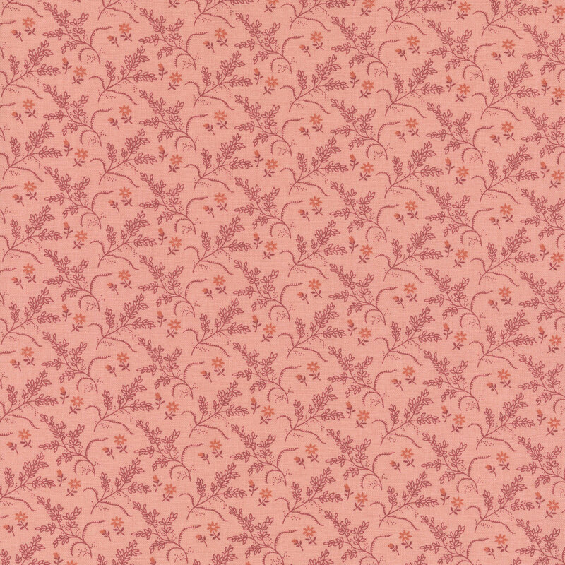 Salmon orange fabric with tonal leafy branches and small orange flowers.