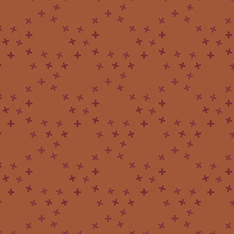 A dusty orange fabric with tossed tonal x's in a large lattice pattern.