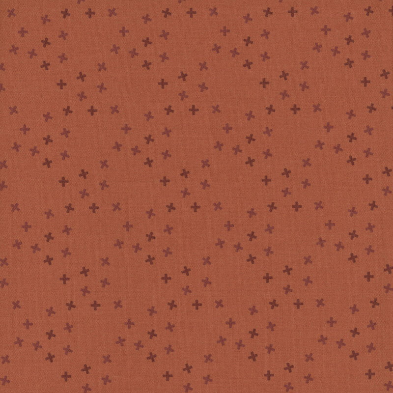 A dusty orange fabric with tossed tonal x's in a large lattice pattern.