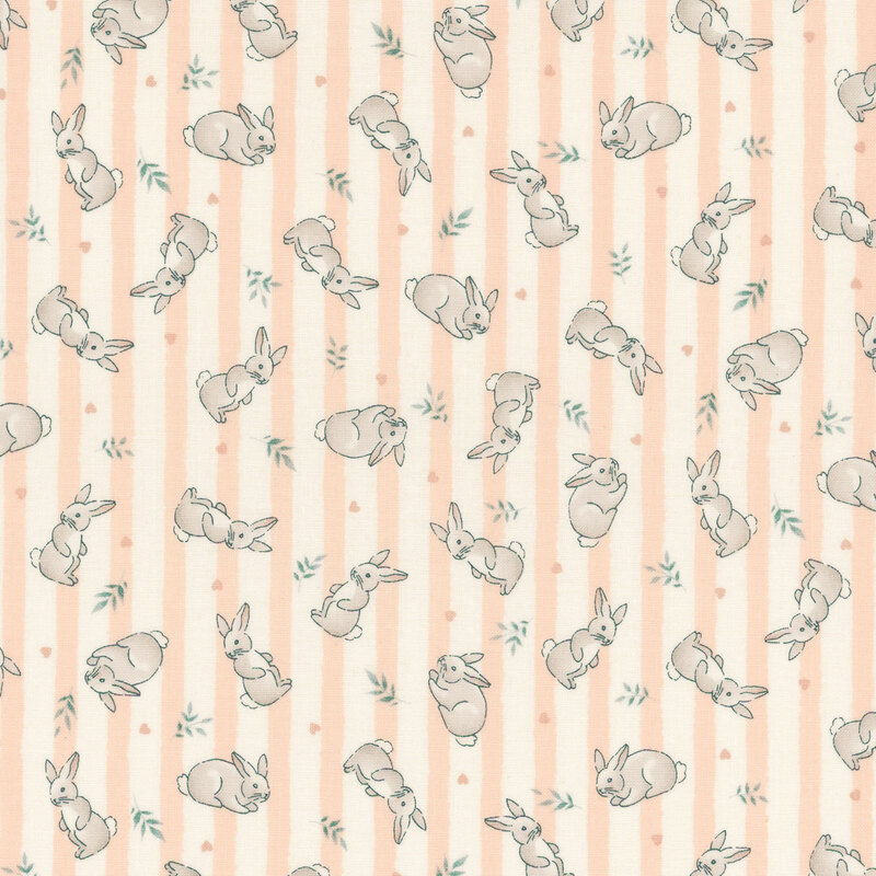Fabric featuring gray rabbits and green leaves on a light peach and cream striped background.