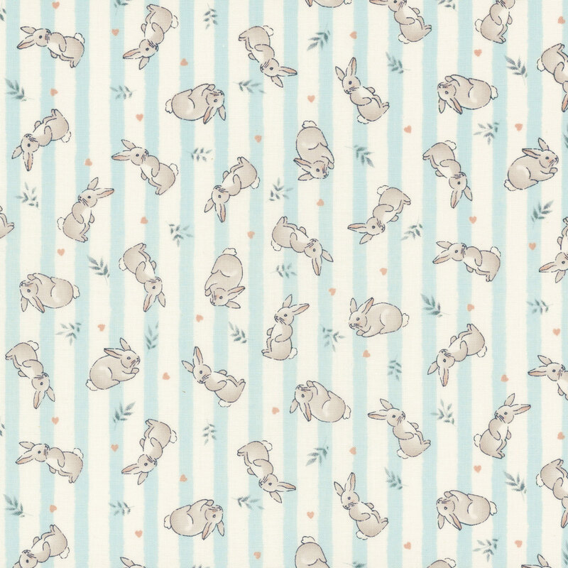 Fabric featuring gray rabbits and green leaves on a light blue and cream striped background.