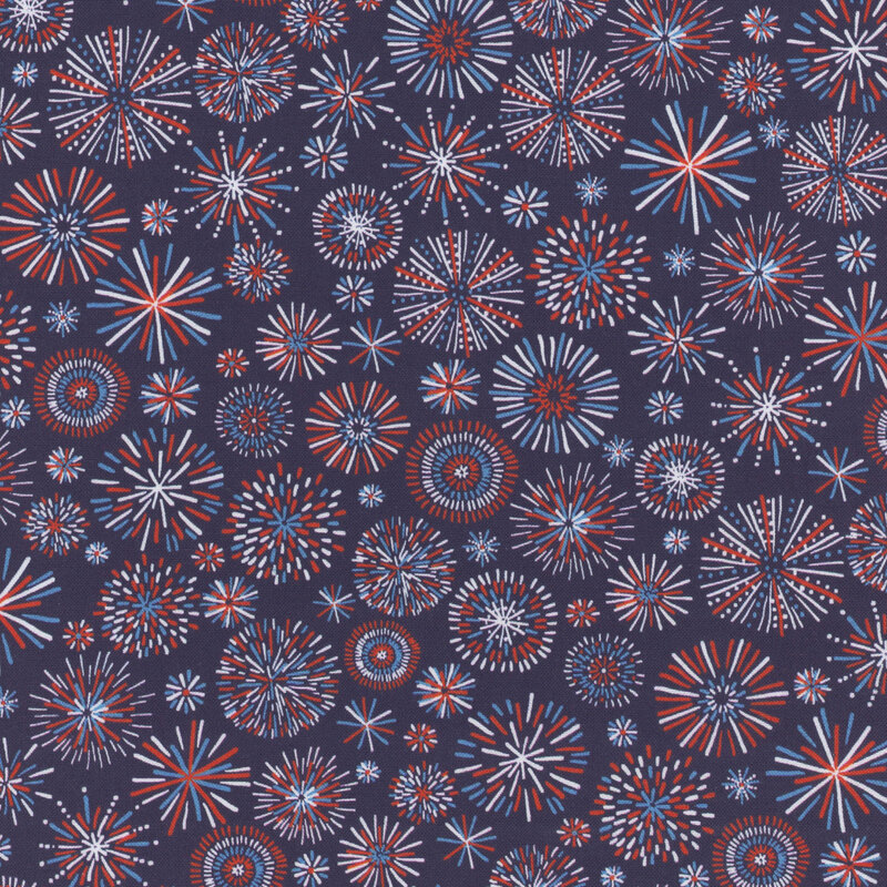 A repeating pattern of colorful fireworks in red, white, and blue against a dark navy fabric.