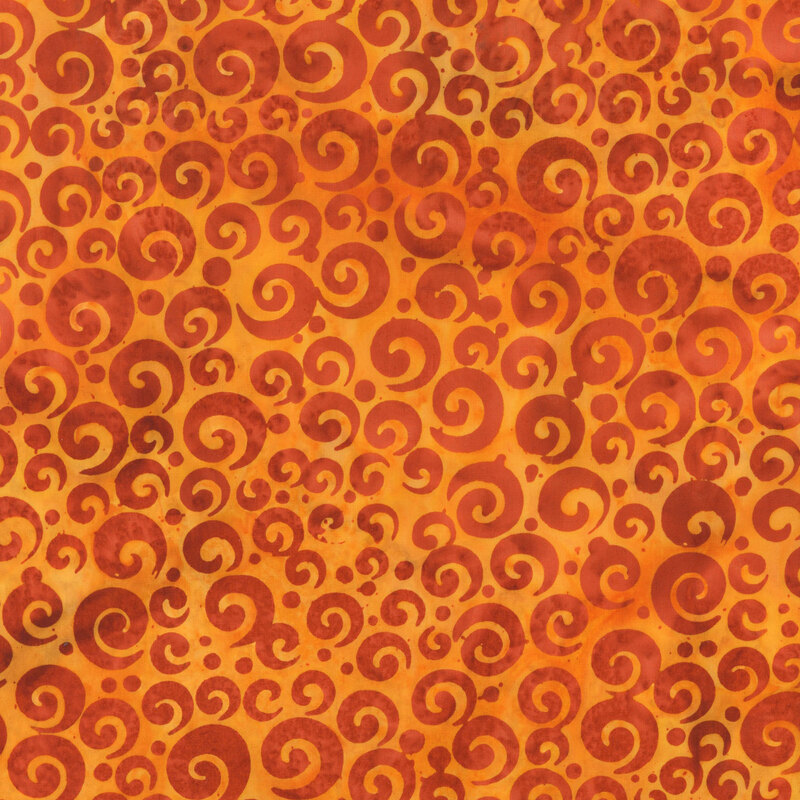 Mottled orange batik fabric with dark orange swirls and dots in varying sizes.
