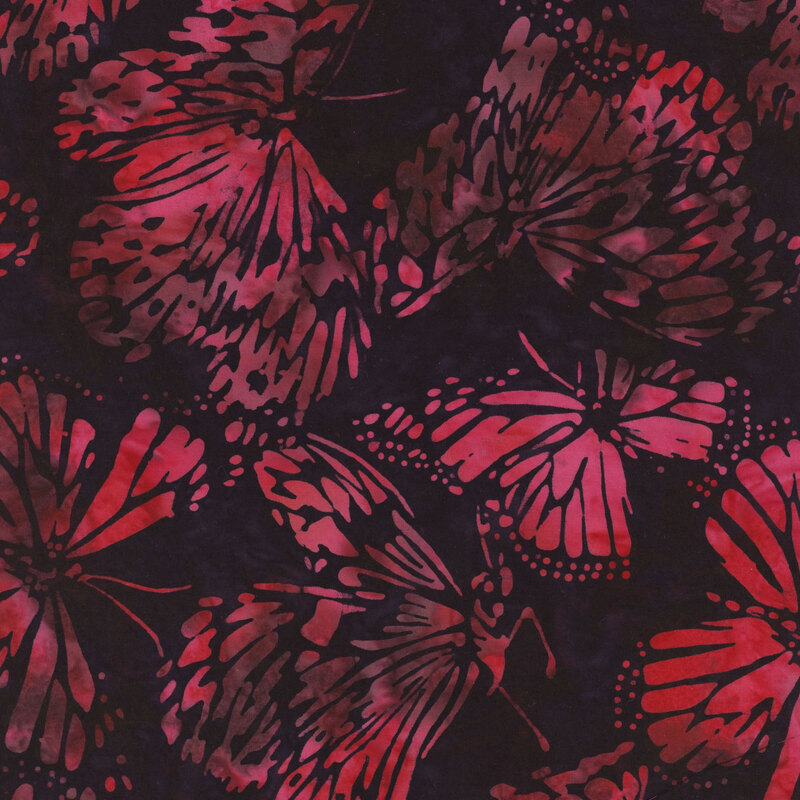 Mottled fuchsia butterflies tossed on a black fabric.
