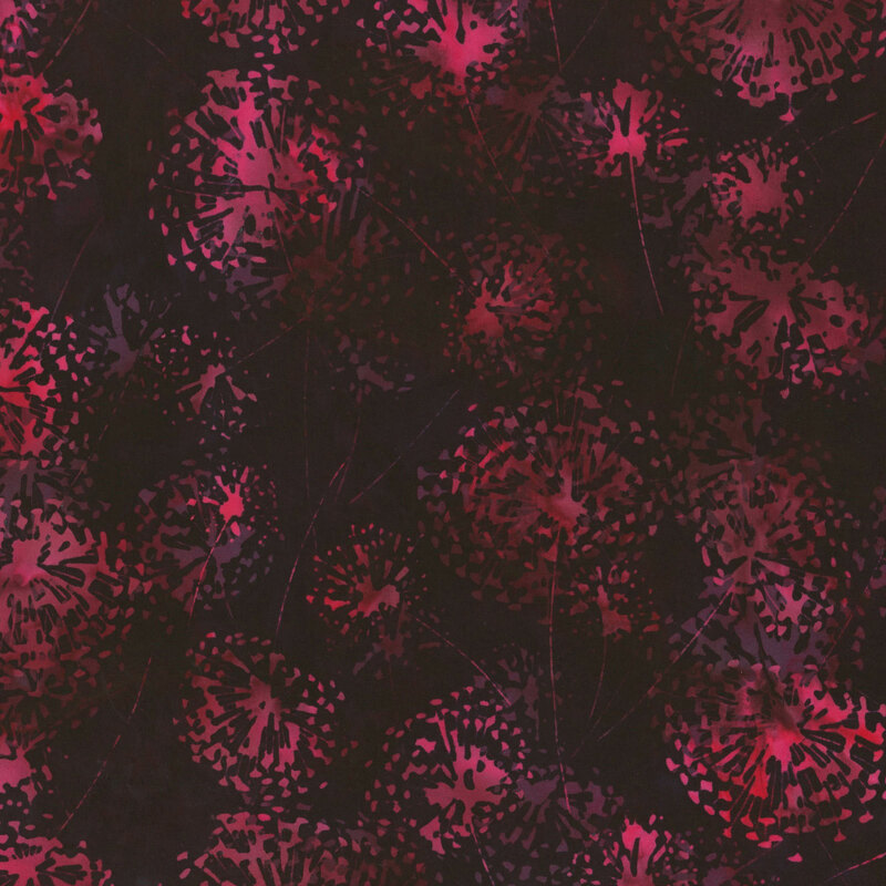 Rose red dandelion flowers tossed on a black fabric.