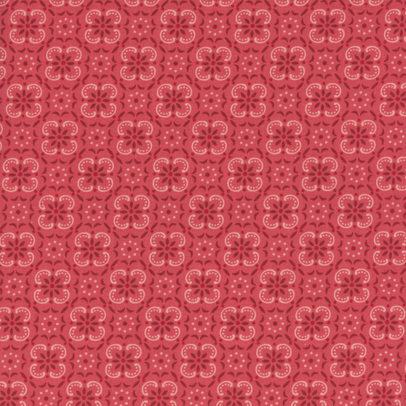 Rose red fabric with a geometric and floral emblem pattern. 