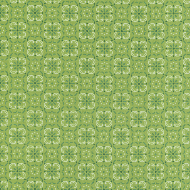 Leaf green fabric with a geometric and floral emblem pattern. 