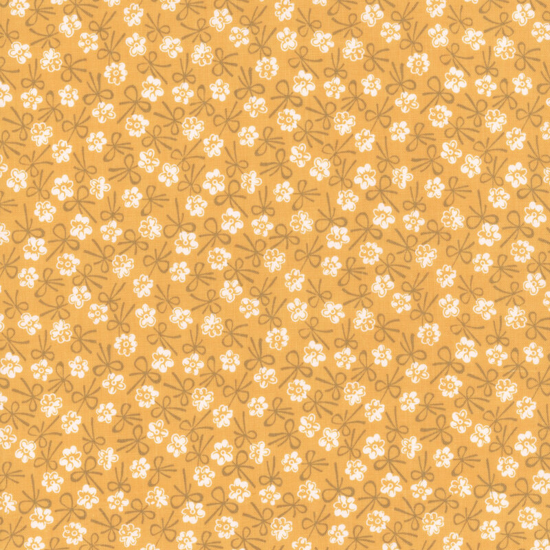 Yellow fabric with a white floral and tonal bow design.