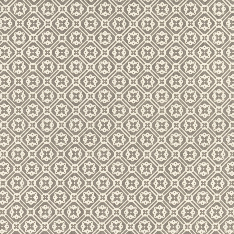 Warm gray fabric with a geometric white floral emblem pattern.