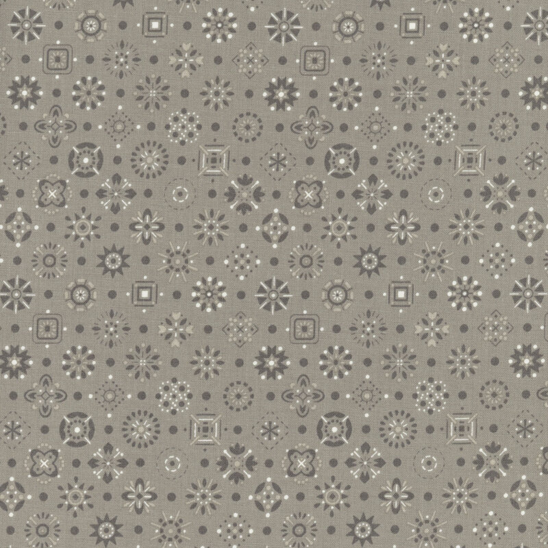 Warm gray fabric with a tonal and white design of scattered emblems.