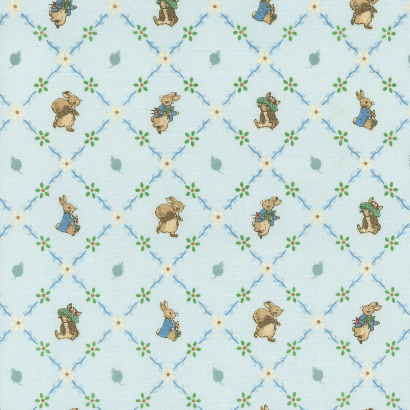 The storybook rabbits, Peter and Benjamin, pose inside floral lattice on light blue fabric.