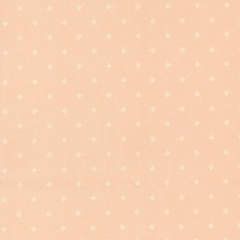 Light peach fabric with a subtle pattern of small white dots.
