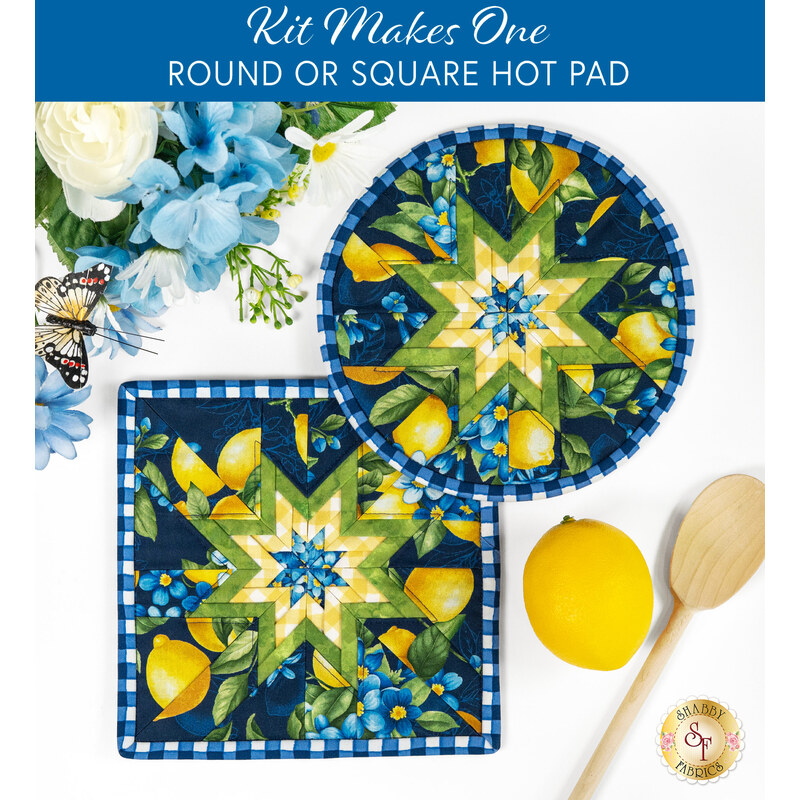 The two completed blue Folded Star Hot Pads, one round and one square, slightly overlapping each other and staged on a white table with coordinating florals, decor, and wooden spoons.
