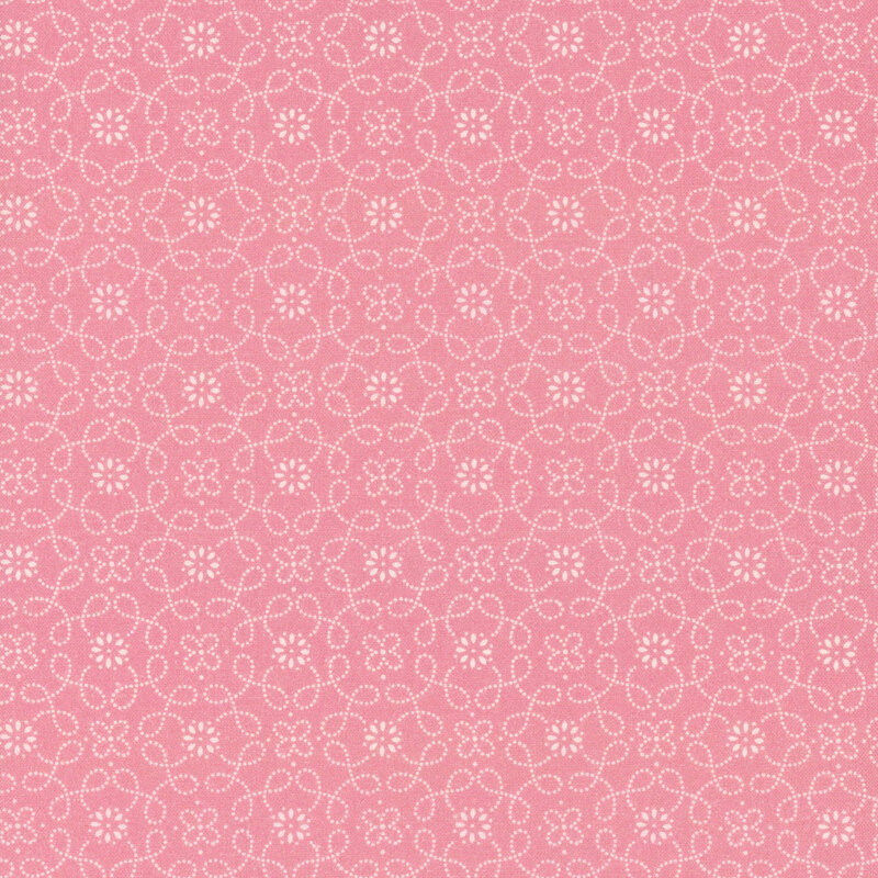 A pink patterned fabric featuring white floral designs and swirling lines.