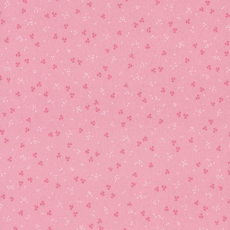 A pink fabric featuring small white and darker pink abstract patterns distributed evenly.