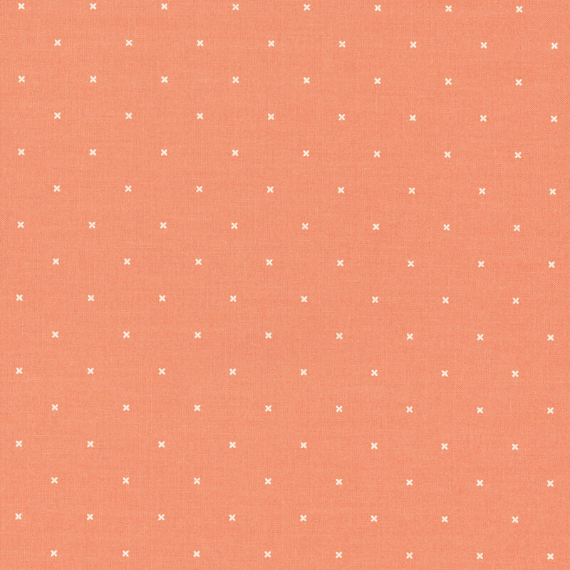 Light coral orange fabric with small x's that resemble cross stitching.